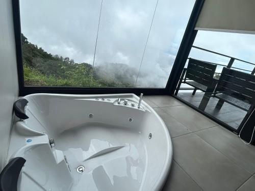 DivisiónVillas Páramo Cloud Forest Hotel的窗户客房内的白色浴缸