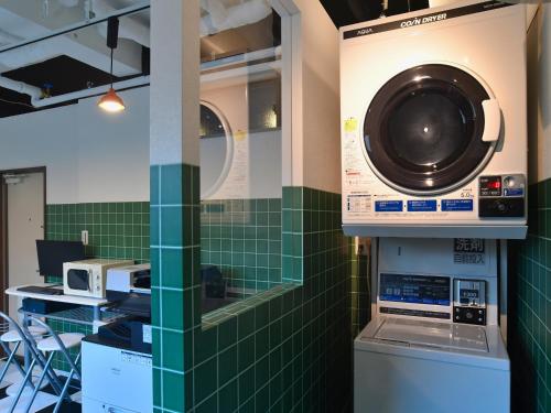 IkutaＦＯＲＢＥＬＬ　ＳＴＡＹ　ＹＵＲＩＧＡＯＫＡ的绿色瓷砖的房间的洗衣机和烘干机