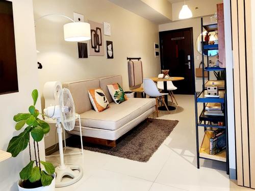 马尼拉Cozy Minimalist Unit at BGC Mall Free Parking的客厅配有沙发和桌子