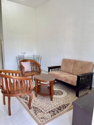 巴特沃思Rumah Kami Homestay的客厅配有沙发和两把椅子