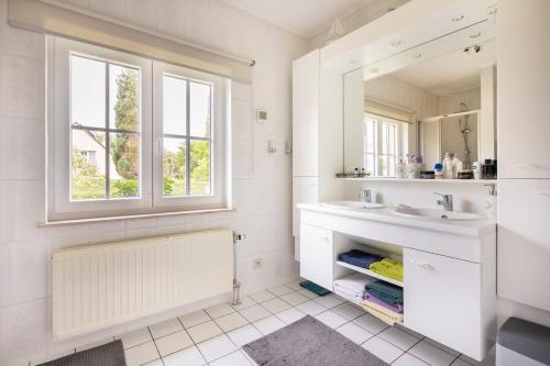 BassengeB&b La Villa Orchidées, breakfast included的白色的浴室设有水槽和镜子