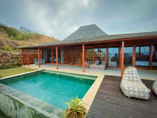 AwangLobster Bay Lombok的一座带游泳池和房子的别墅
