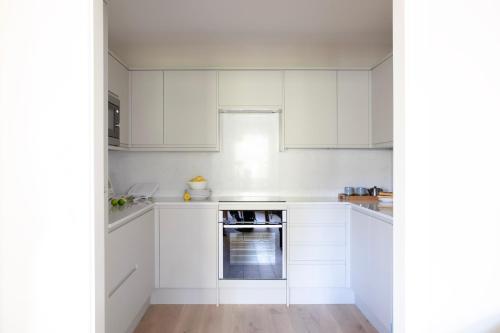 伦敦Gulaid House Knightsbridge by Bob W London的白色的厨房配有白色橱柜和烤箱