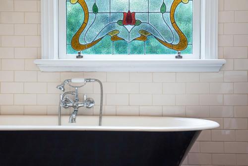 CarnegieTimeless Gem in Malvern East的浴缸上方设有彩色玻璃窗