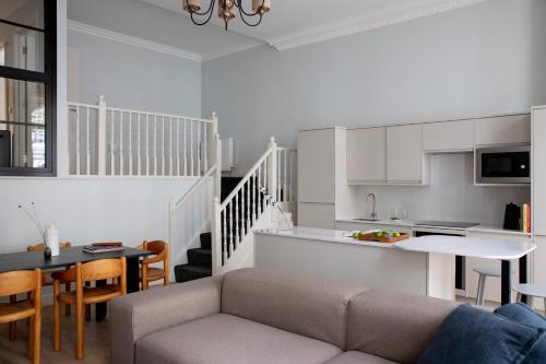 伦敦Gulaid House Knightsbridge by Bob W London的客厅以及带沙发和桌子的厨房。