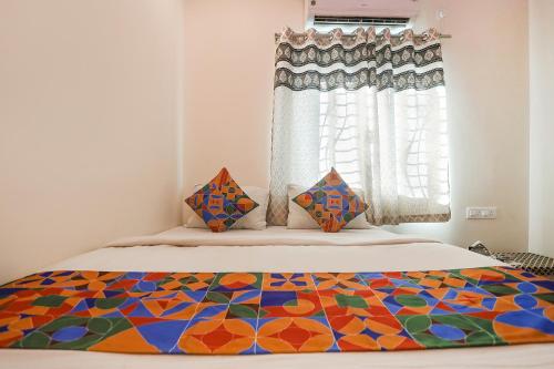 那格浦尔FabExpress Shivas Inn的一间卧室,床上有五颜六色的被子
