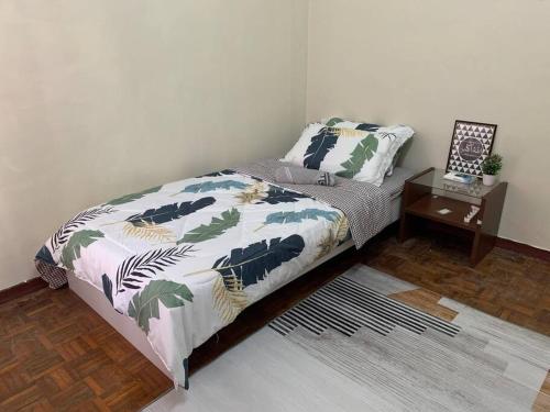 万挠Tulip Hijau Homestay - Bukit Beruntung - 4Bedrooms的一间卧室配有一张床,床头柜配有桌子