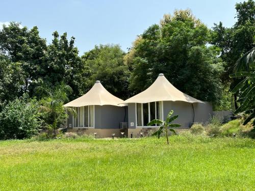 新德里Chitragarh Farm的草场上的两顶白色帐篷
