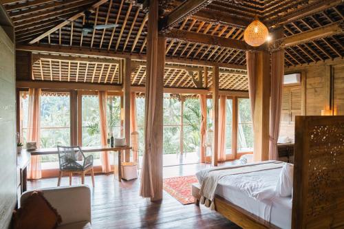 乌布Ubud Riverside Villa的一间设有床铺的卧室,位于带窗户的房间内