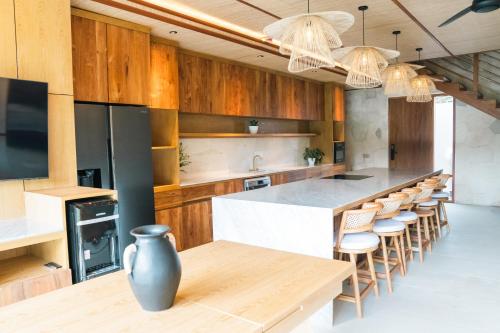 乌布Ubud Riverside Villa的厨房配有木制橱柜和桌椅