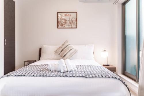 大阪川HOUSE旭的一张白色的床,上面有两个枕头