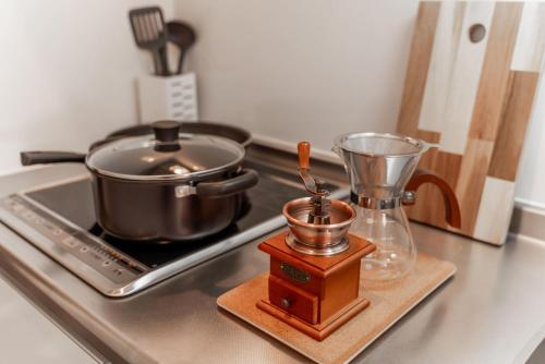 大阪川HOUSE旭的厨房柜台配有锅和炉灶上的搅拌机
