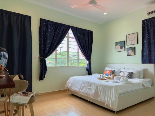 哥打京那巴鲁NewWALAI N3 Landed house near IMAGO KK with CarGarage的一间卧室配有一张带蓝色窗帘的床和一扇窗户
