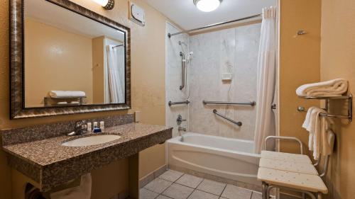卡温顿SureStay Plus by Best Western Covington的浴室配有水槽、淋浴和浴缸。