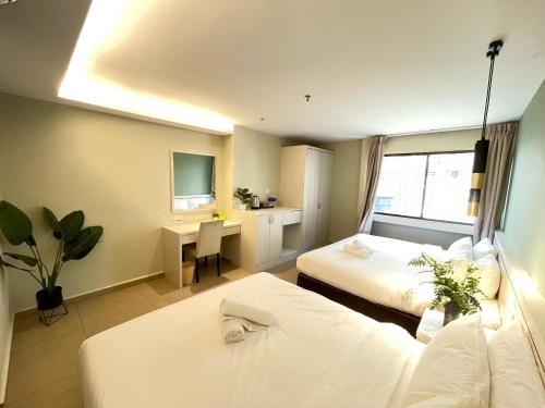 吉隆坡Swing & Pillows - Sungei Wang Hotel Bukit Bintang的酒店客房配有两张床和一张书桌