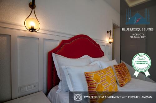 伊斯坦布尔Blue Mosque Suites 2 - Old City Sultanahmet的一张带红色床头板和一些枕头的床