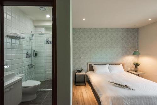 鱼池乡巧人文旅民宿的一间卧室配有一张床,浴室设有淋浴。