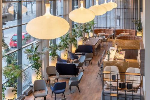 考纳斯Radisson Hotel Kaunas的餐厅设有桌椅和大窗户