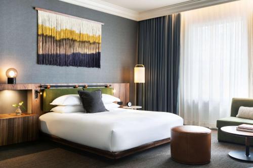 西雅图The Alexis Royal Sonesta Hotel Seattle的酒店客房带一张大床和一把椅子