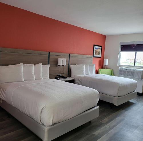 卡尔斯巴德Best Western Plus Executive Residency Carlsbad Hotel的红色墙壁的酒店客房内的两张床