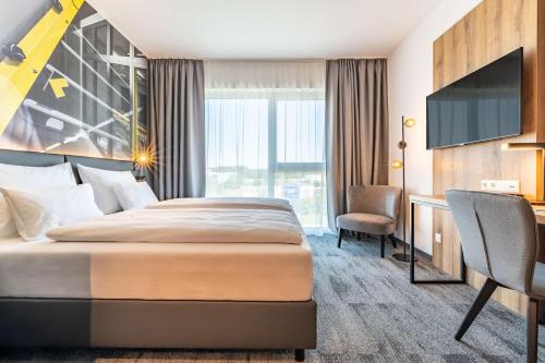 施泰尔Aiden by Best Western Stadtgut Hotel Steyr - FREE PARKING的配有一张床和一张书桌的酒店客房