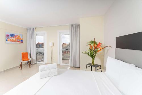 威廉斯塔德Brion City Hotel BW Signature Collection的白色的卧室设有一张大床和一个窗户