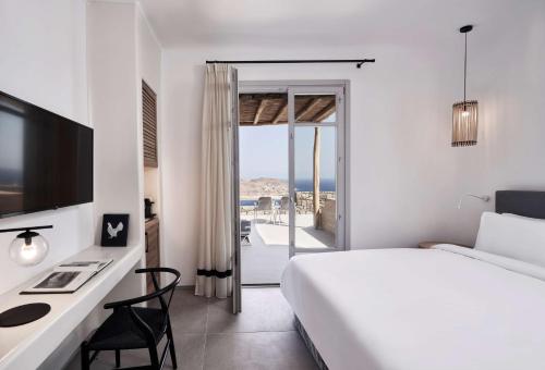 凯勒里瓦迪Radisson Blu Euphoria Resort, Mykonos的白色的卧室配有床和书桌及电脑