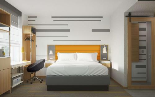 纽约Hampton Inn by Hilton New York Times Square的一间卧室配有一张床、一张桌子和一把椅子
