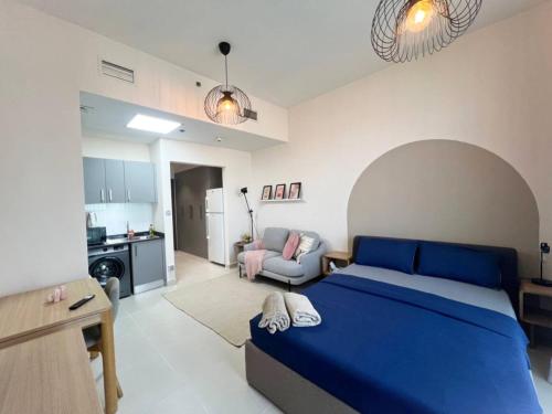 迪拜Warm and Elegant Studio in Dubai的一间带蓝色床的卧室和一间客厅