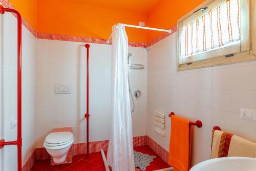 PopiglioTramonto al Rifugio Arcobaleno的橙色的浴室设有卫生间和淋浴。