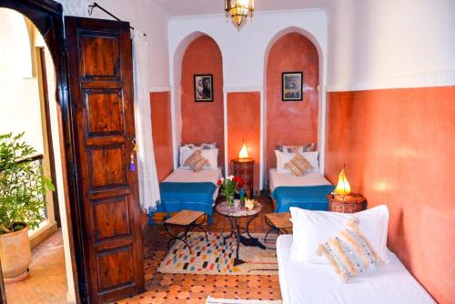 马拉喀什答图斯卡酒店的客厅配有两张床和一张桌子