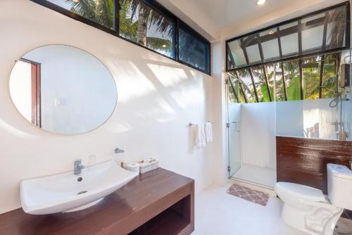 卢纳将军城Casa Bianca Siargao的一间带水槽、卫生间和镜子的浴室