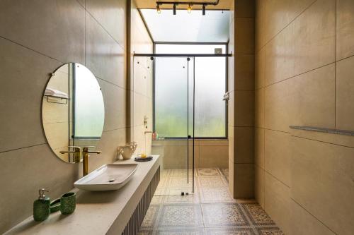 新德里StayVista's Anantam - Villa with Massive Outdoor Pool with Deck & Sprawling Lawn的一间带水槽和镜子的浴室