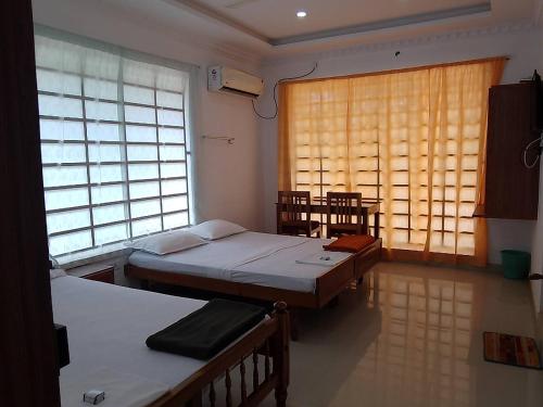 可瓦兰Somatheertham Panchakarma Resort的客房设有两张床和窗户。