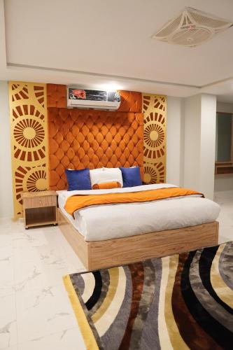 伊斯兰堡Nüva Hotel的一间卧室配有一张带木制床头板的床