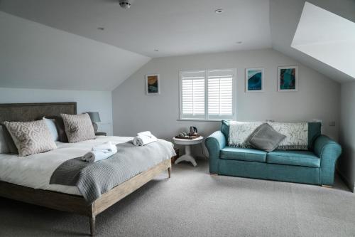 Saint ErvanMacdonald's Farm的一间卧室配有一张床和一张蓝色的沙发