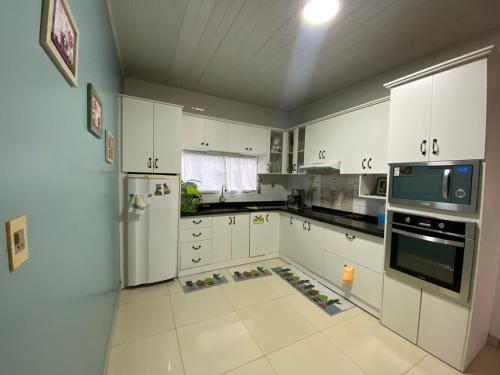 埃斯特城Casa Bignonia Amplio y confortable Ideal para familias con niños y mascotas的一间大厨房,配有白色的橱柜和一台冰箱