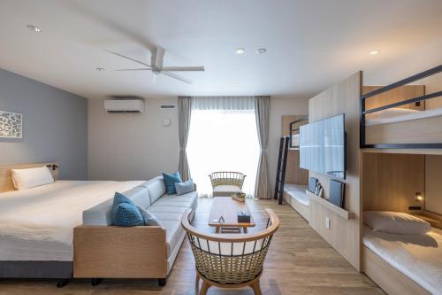 Tsuboyaアルファベットイン那覇国際通りWEST的一间卧室配有一张床、一张沙发和一张桌子