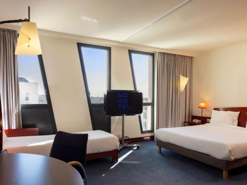马赛马赛欧洲地中海中心诺富特套房酒店的酒店客房设有两张床和一台平面电视。