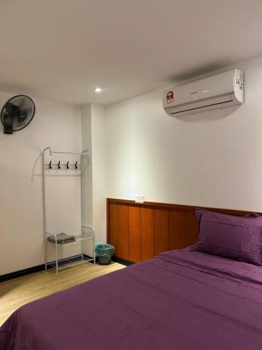 拿笃The Garden House Lahad Datu的一间卧室配有一张带紫色棉被的床
