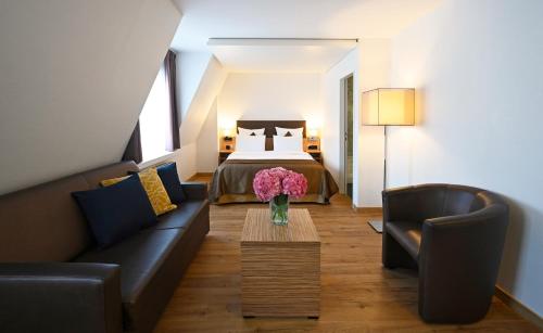 苏黎世Hotel Stoller的客厅配有床、沙发和桌子