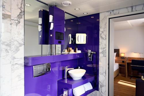 苏黎世Hotel Stoller的紫色浴室设有水槽和卫生间