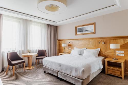 索波特Haffner Hotel & SPA Sopot的酒店客房带一张床、一张桌子和椅子