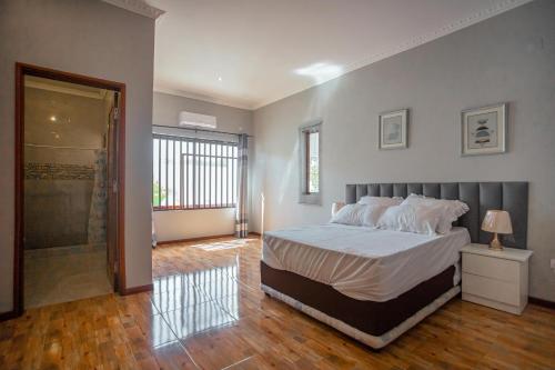 蓬塔杜欧鲁Ponta d’ ouro lia’s house的一间卧室设有一张床和一个步入式淋浴间。