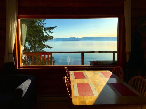 Gillies BayThe Beach House Texada - Waterfront Cabin的一张桌子,从窗口可欣赏到水景