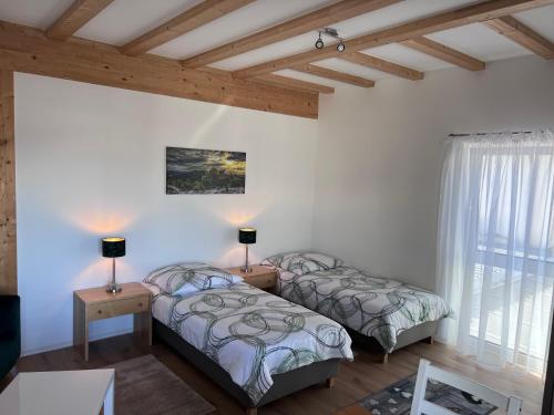 EngelsbrandFerienwohnungen Auf der Höhe的配有白色墙壁和木制天花板的客房内的两张床