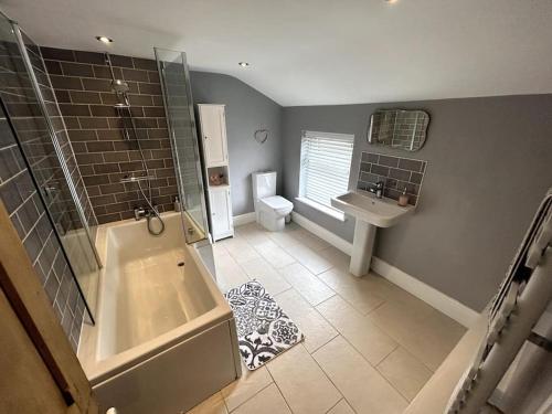 克鲁Two Bed Charming Cottage的带浴缸、卫生间和盥洗盆的浴室