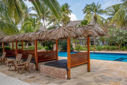 米查维米查维日落湾度假酒店的一个带游泳池、草伞和椅子的度假胜地