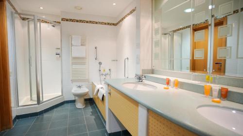 博尔顿Bolton Stadium Hotel的一间带两个盥洗盆和卫生间的浴室