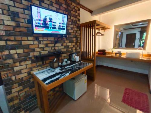高兰Lanta Riviera Resort - SHA Extra Plus的一间客厅,在砖墙上配有电视